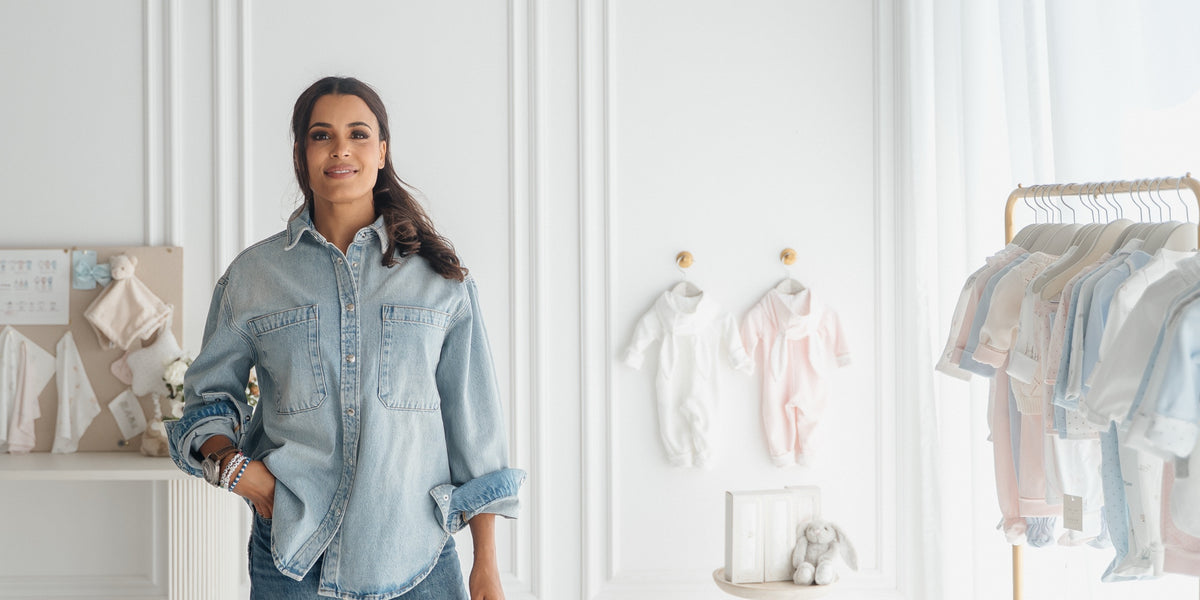 Woman in nursery with baby clothing collection
